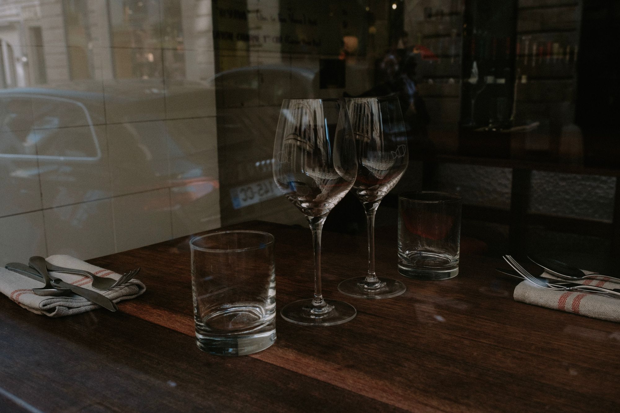 Gedeckter Tisch mit Weingläsern im gedimmten Licht